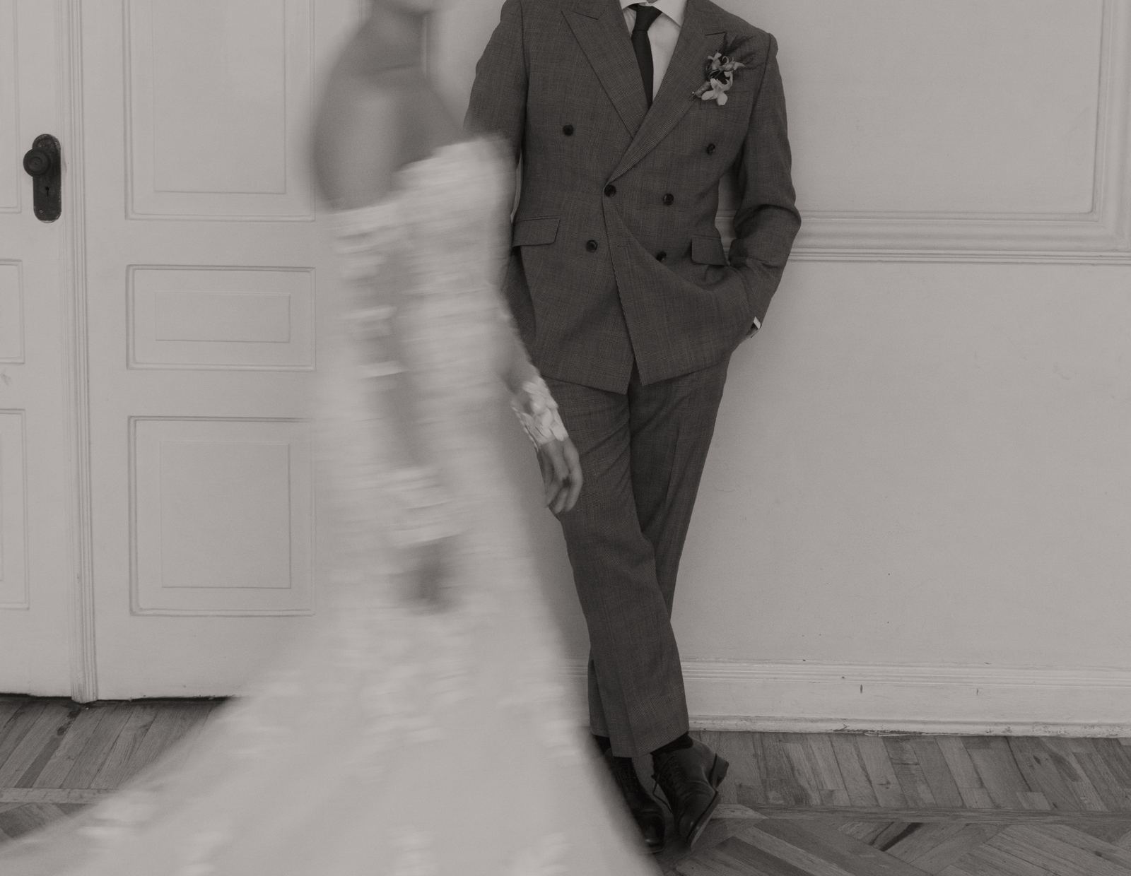 Groom in a double-breasted suit as the bride sweeps past in motion