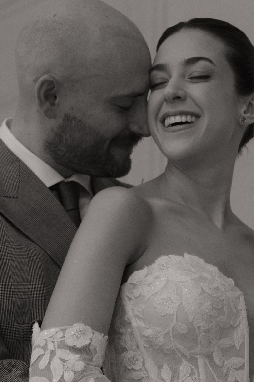 Groom nuzzling the smiling bride's cheek, black and white